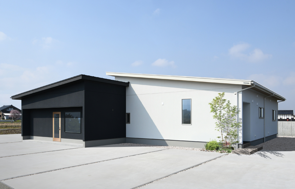 美容室(黒)と住居(白)を色で分けた、スタイリッシュな外観。